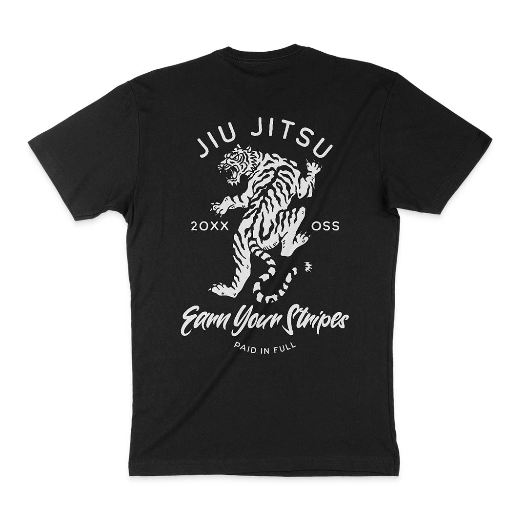 This Earn Your Stripes - Black T-shirt features a white illustration of a tiger and the text "JIU JITSU," "20XX OSS," "Earn Your Stripes," and "PAID IN FULL.