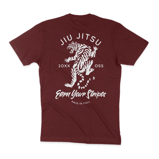 A maroon T-shirt, Earn Your Stripes - Maroon, features a graphic of a tiger and the words "Jiu Jitsu", "20XX", "OSS", and "Earn Your Stripes Paid in Full" printed on the back in bold white text.