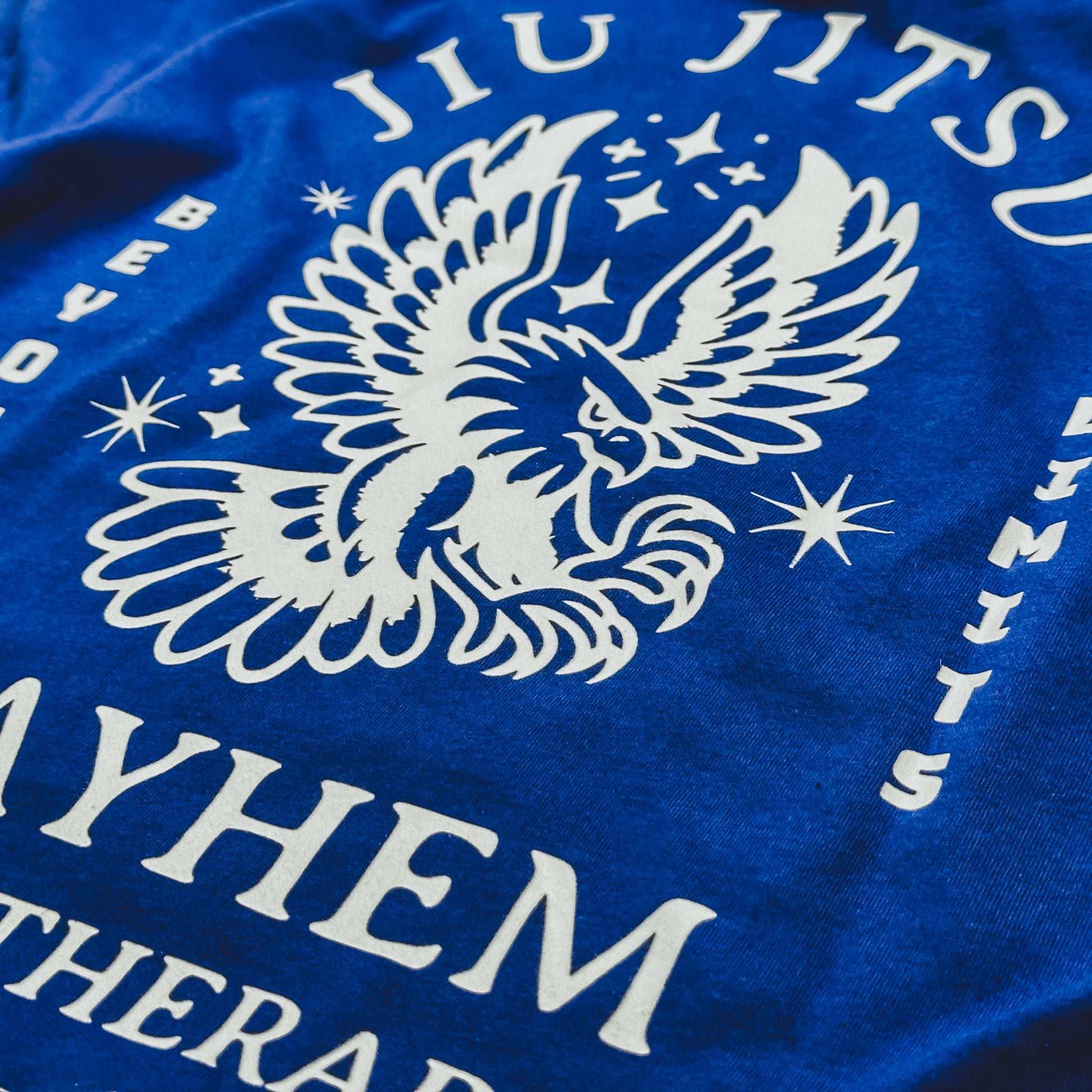 The "Beyond Limits - Royal" T-shirt features a bold white illustrated eagle combined with the inspiring text: "Jiu Jitsu," "Beyond Limits," and "Mayhem Therapy.