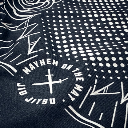 Close-up of the Emerge Victorious - Black fabric, featuring white graphic patterns with the text "MAYHEM ON THE MAT" and "JIU JITSU" encircling two crossed swords, capturing the essence of the warrior spirit.