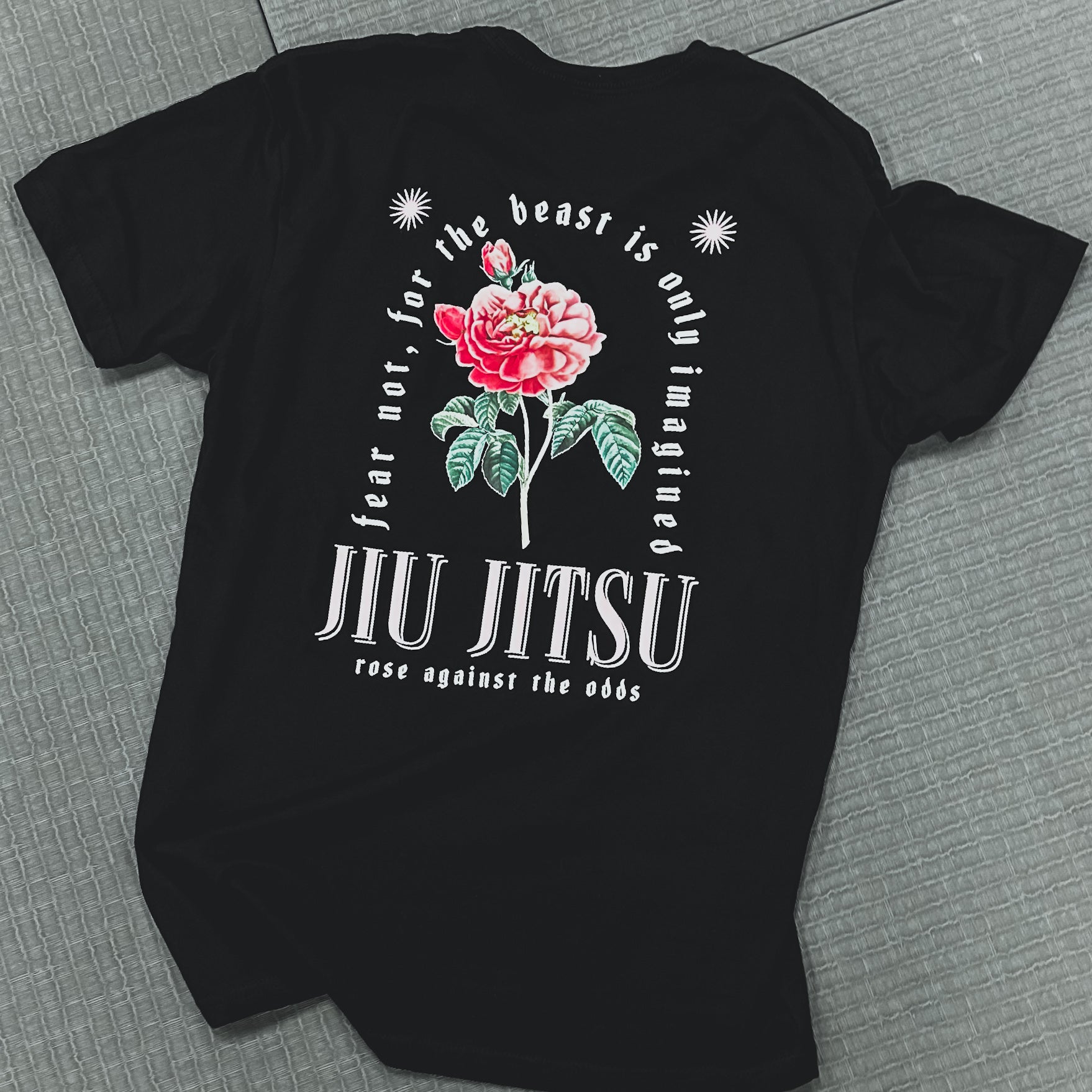 Black t-shirt from "The Beast Is Only Imagined - Black" collection, showcasing a rose illustration and the text: "Fear not, for the beast is only imagined. Jiu Jitsu." Perfect for celebrating overcoming adversity like an enchanted rose blooming against the odds.